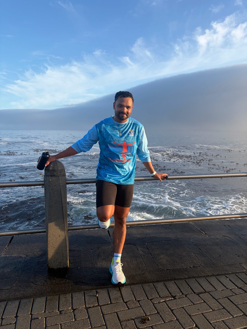 Shaun Cedric Thomas on the Sea Point promenade at sunrise with a fog bank over the sea